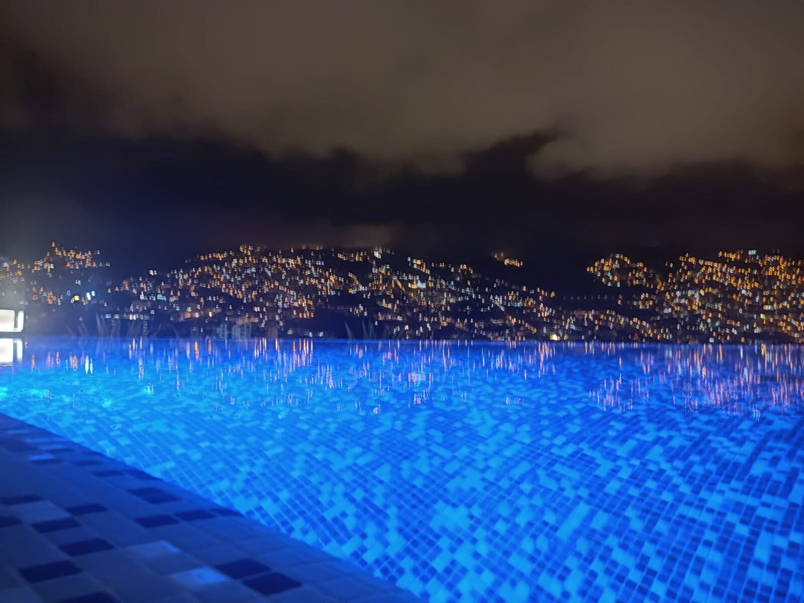 Pool Funchal rooftop with city lights reflecting on the water surface